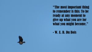 Large bird flying in the bottom left of a clear blue sky. With quote, “The most important thing to remember is this: To be ready at any moment to give up what you are for what you might become.” - W. E. B. Du Bois